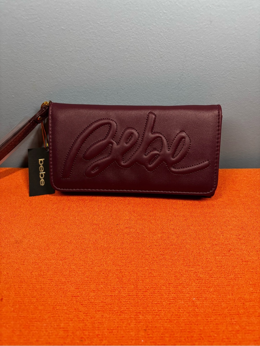 bebe Embossed Script Logo Wristlet in Plum